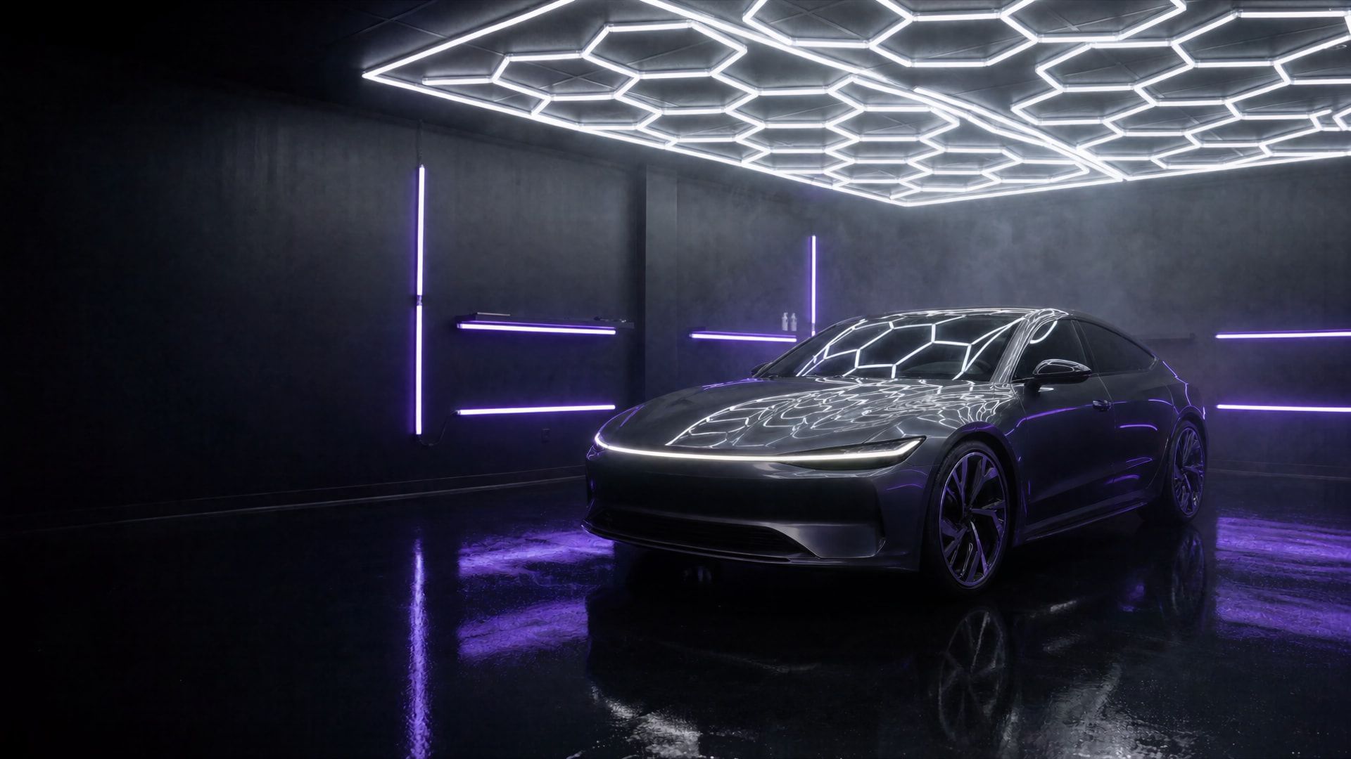Dunkelgraue Sportlimousine im Studio unter sechseckigen LED-Deckenleuchten